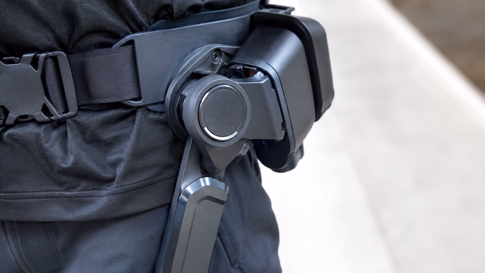 Randonneur senior équipé d'un exosquelette d'assistance active marchant sur un sentier de montagne au lever du soleil